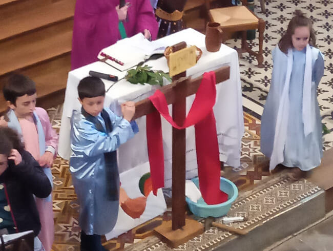 Messe des Rameaux à Isturitz avec les enfants  : Les 2 bandits crucifiés près de Jesus. un écriteau a été placé près de la croix