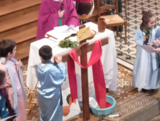 Messe des Rameaux à Isturitz avec les enfants  : Les 2 bandits crucifiés près de Jesus. un écriteau a été placé près de la croix